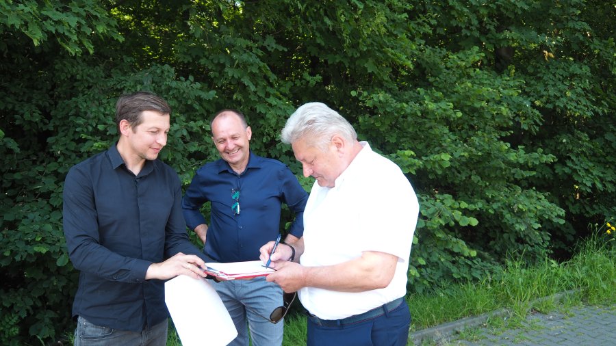 Odbiór przebudowanej ul. Nadwiślańskiej w Bobrku. Burmistrz Chełmka podpisuje protokół odbioru robót.
